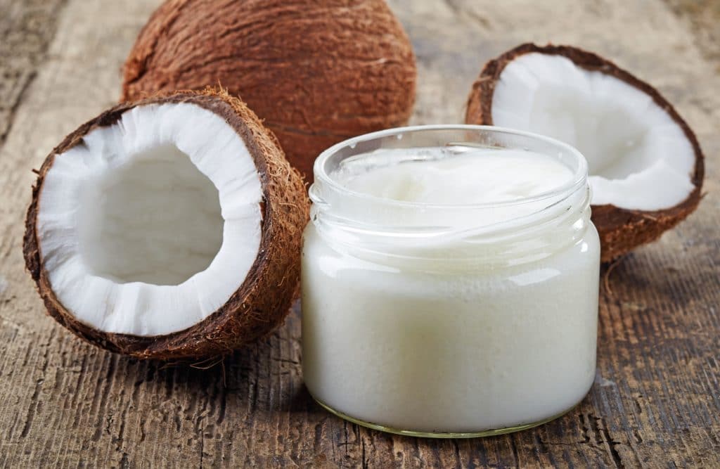 fresh coconuts and a jar of coconut oil